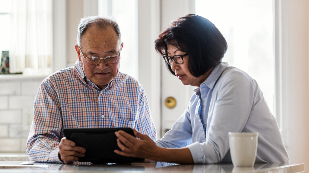couple looking at tablet assessing health care costs