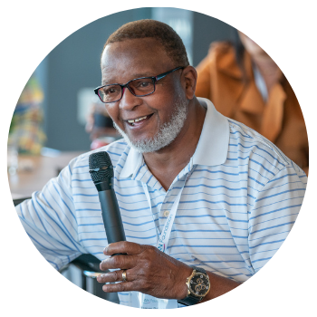 Man holding a microphone talking at a PAN advocacy event