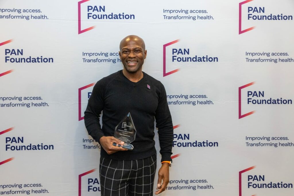 Tony standing holding his award at a PAN event